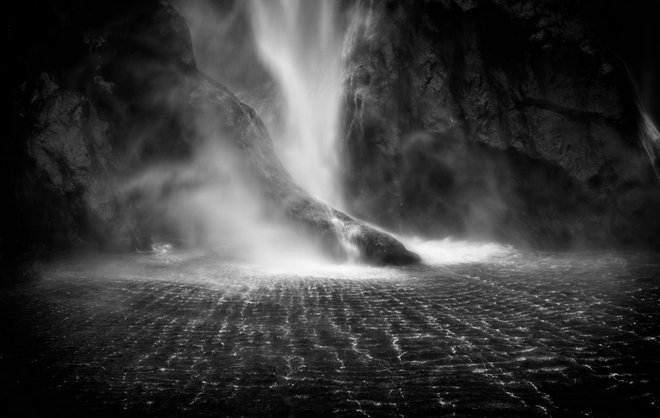 BASE OF WATERFALL IN MILFORD SOUND NEQ ZEALAND IN BLACK AND WHITE